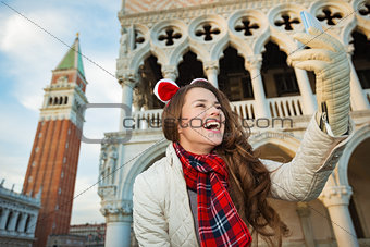 Happy woman tourist taking Christmas selfie in Venice, Italy