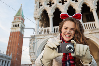 Happy woman tourist with camera on Christmas in Venice, Italy