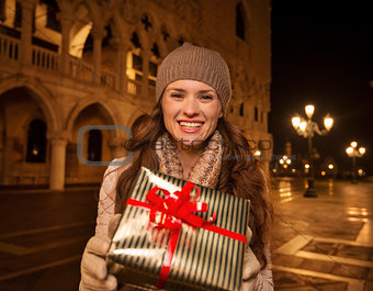 Woman showing Christmas gift box on Piazza San Marco, Venice