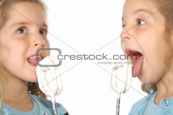 shot of twin children licking beaters