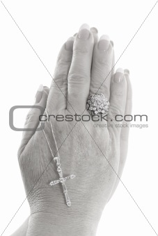 shot of praying hands with cross black & white