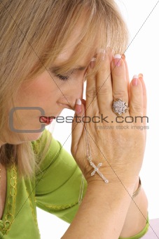 shot of a woman praying with rhinestone cross upclose