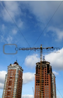 yellow crane and two orange tall buildings
