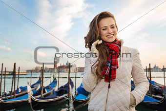 Dreamy woman traveler standing on embankment in Venice, Italy