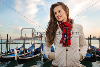 Young woman traveler standing on embankment in Venice, Italy