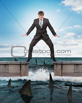 Businessman standing above sharks
