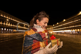 Woman looking on Christmas gift box on Piazza San Marco, Venice