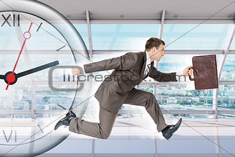 Businessman running with clock in building