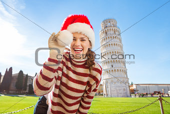 Woman playing with Santa hat in front of Leaning Tour of Pisa