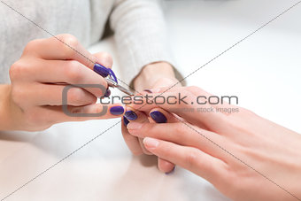 Beautician remove cuticle from ring finger client