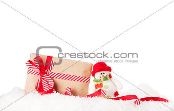 Christmas gift box and snowman in snow