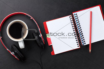Desk with notepad, coffee and headphones