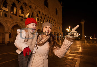 Mother pointing on something to child on Piazza San Marco
