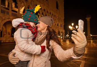 Mother and child hugging while taking selfie on Piazza San Marco