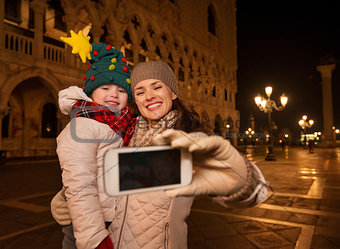 Mother and child taking selfie on Piazza San Marco in Venice
