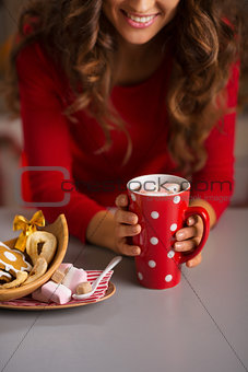 Woman having cup of hot chocolate and Christmas sweets. Closeup