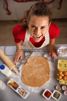 Modern housewife making Christmas themed cookies in kitchen