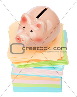 Pink piggy bank on pile of stickers