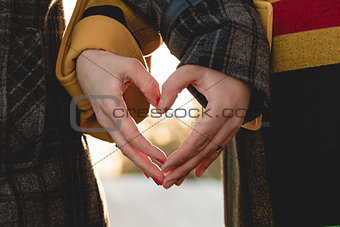 bride and groom holding hands in shape of heart