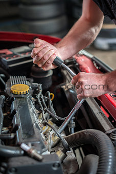 Car mechanic in auto repair service, starting ignition plug