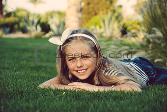 Beautiful, happy, young girl lying on the grass.