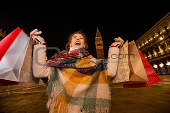 Woman with shopping bags rejoicing on Piazza San Marco in Venice