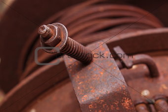 Closeup of a screw and steel cable wrapped in a roll