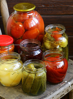canned fruits and vegetables in jars on a wooden chair