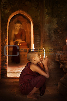 Buddhist novices praying in monastery 