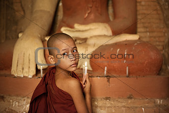 Buddhist novices lighting up candlelight in temple