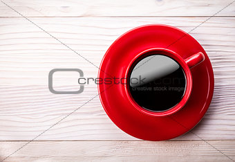 Red coffee cup on light wooden table