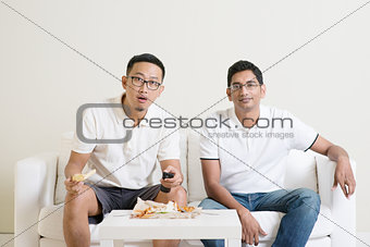 Men friends watching sport match on tv