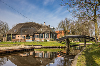 Old farm with reflection in the water in Giethoorn