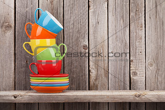Colorful coffee cups on shelf