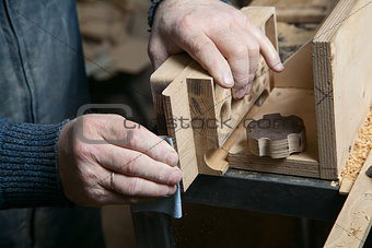 Man sandpaper grinds wood product in the shop