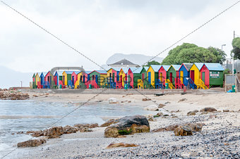 Multi-colored beach huts at St. James with railroad passing by