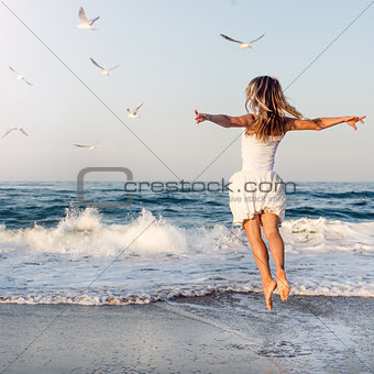 Beautiful girl  jumping on sea