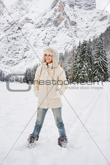 Woman in white coat and fur hat standing in winter outdoors