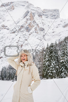 Woman in coat and hat standing in winter outdoors and laughing