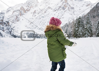 Seen from behind child in green coat playing outdoors
