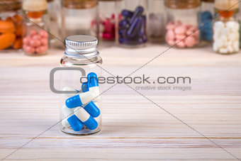 Blue white colored capsules in glass container