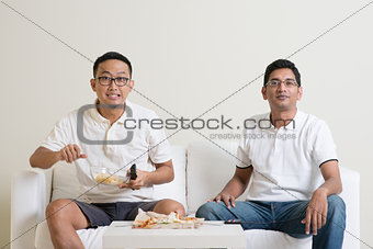 Men watching live sport match on tv together