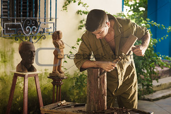 Young Sculptor Artist Working And Sculpting Wood Statue