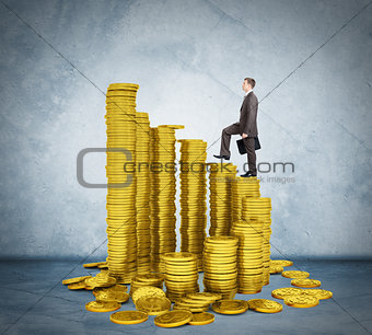 Businessman walking on stack of coins