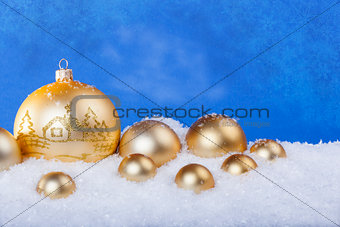gold Christmas balls in the snow