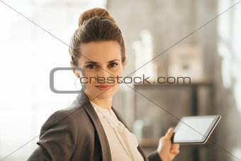 Portrait of business woman holding tablet in loft apartment
