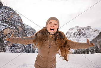 Woman rejoicing outdoors among snow-capped mountains