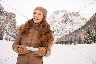 Young woman with cell phone outdoors among snow-capped mountains