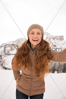 Woman taking selfie outdoors among snow-capped mountains