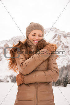 Happy young woman outdoors among snow-capped mountains
